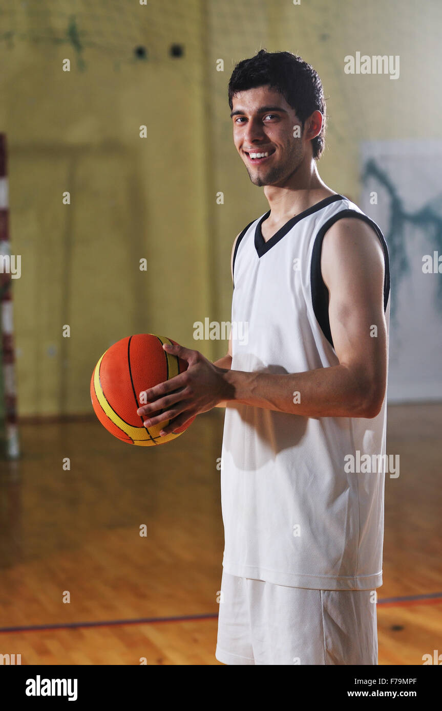one healthy young man play basketball game in school gym indoor Stock