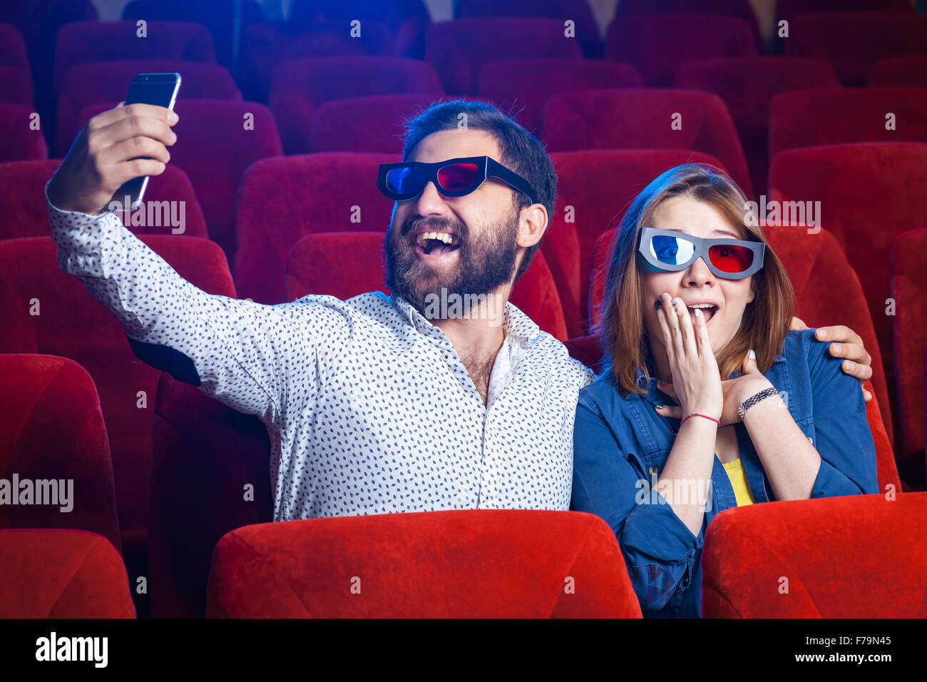 The spectators sitting in the cinema and watching movie. Concept of a ...