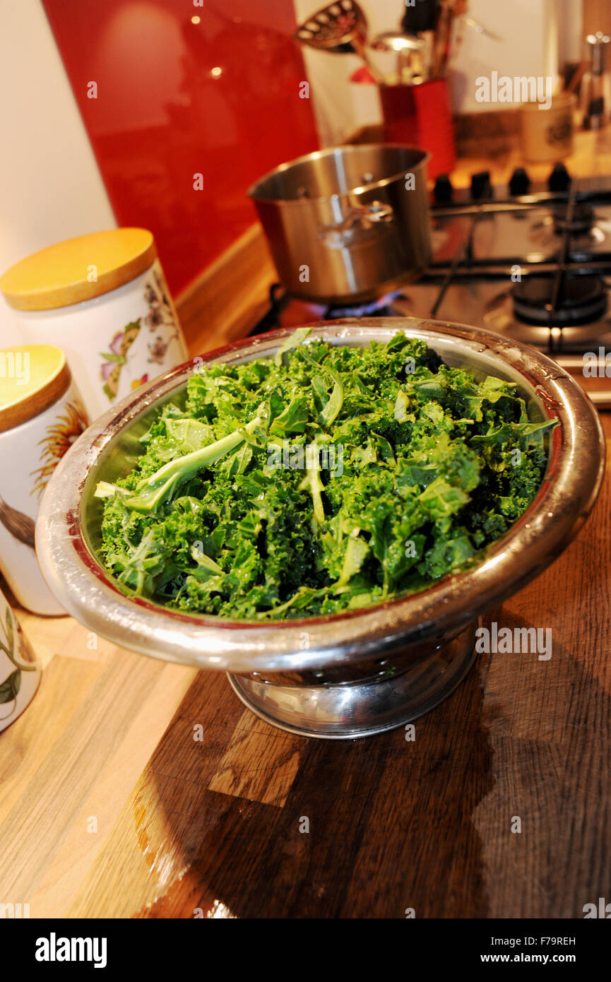 Curly Kale green vegetable washed and ready to cook in a colander Stock