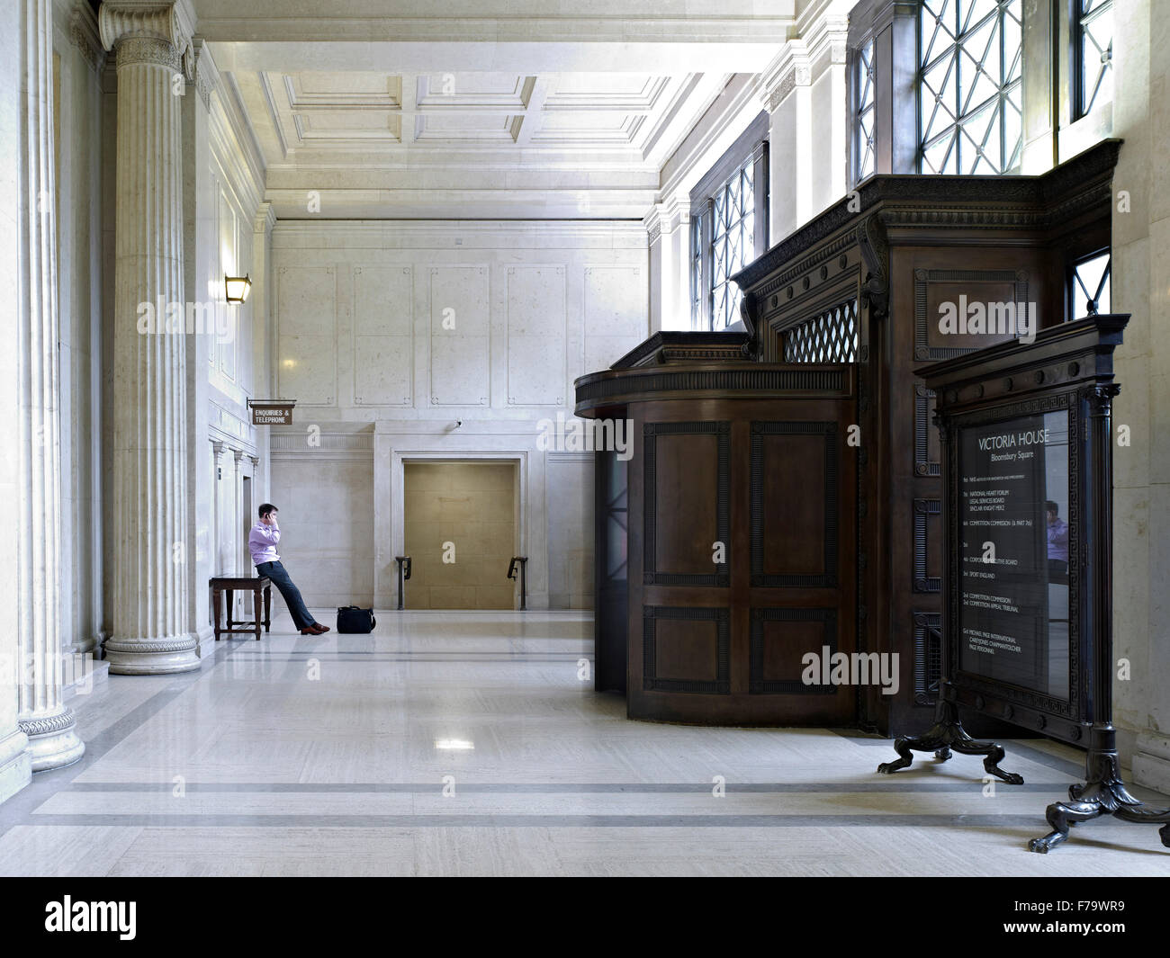 Man standing in entrance foyer of Victoria House, Bloomsbury, London, England, UK Stock Photo