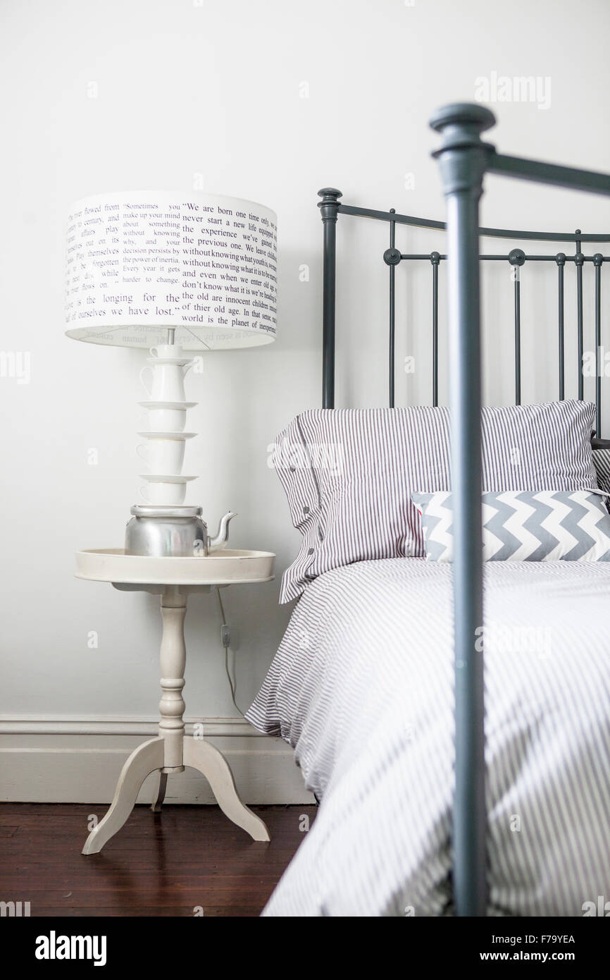 Metal bed and teacup lampstand in Sydney home of designer and Heritage Consultant Janine Hendry. Stock Photo