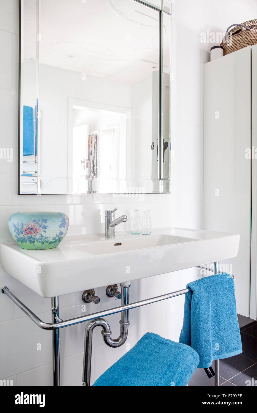 Mirror above sink with blue towels in Sydney home of designer and Heritage Consultant Janine Hendry. Stock Photo