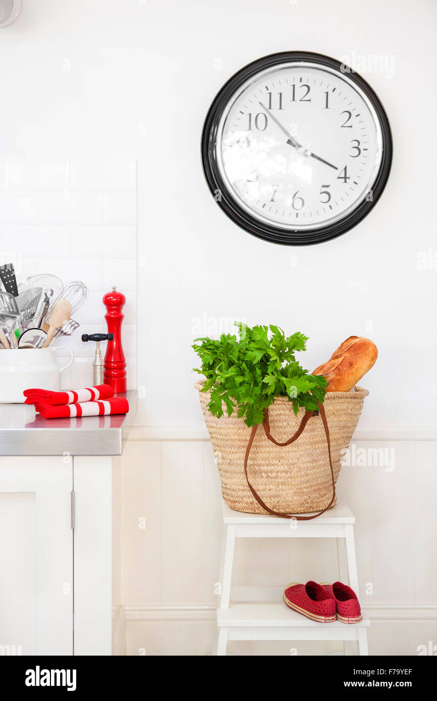 Parsley and bread in bag below clock, kitchen detail in Sydney home of designer and Heritage Consultant Janine Hendry. Stock Photo