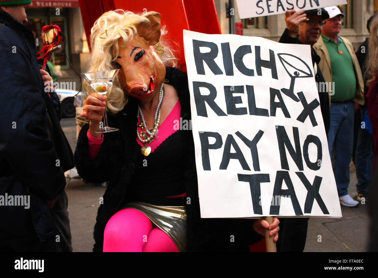 A person in a pig costume holds a sign 'Rich Relax Pay No Tax' at a Occupy Wall Street demonstration in Zuccotti Park. New York, NY. March 17, 2012. Stock Photo