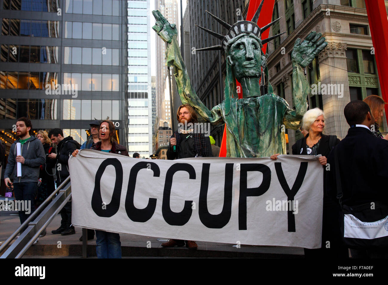 An Occupy Wall Street gathering with an Occupy banner and Lady Liberty puppet in Zuccotti Park (March 17, 2012) Stock Photo