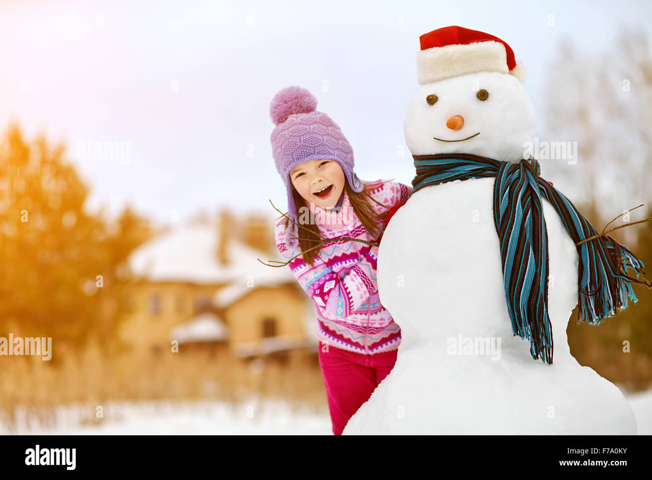 kid playing with snowman Stock Photo