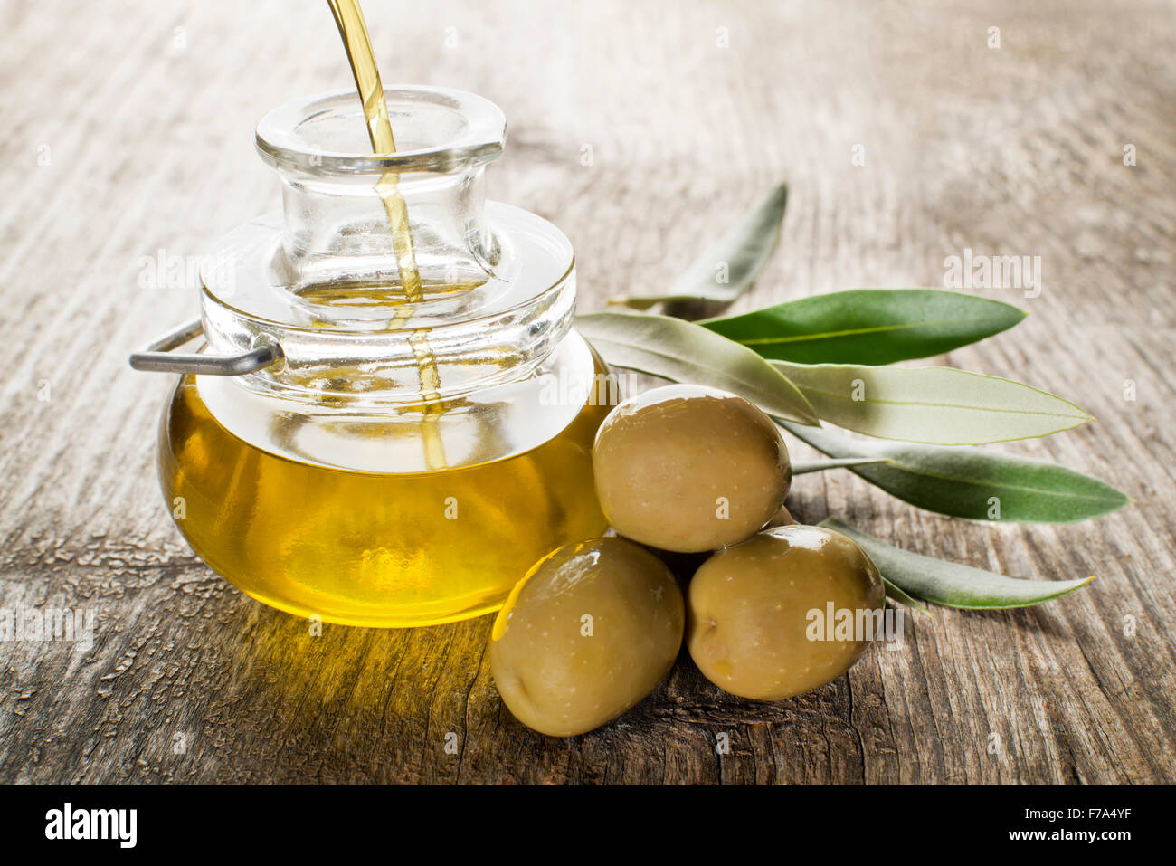 Virgin olive oil pouring in the bottle. Stock Photo