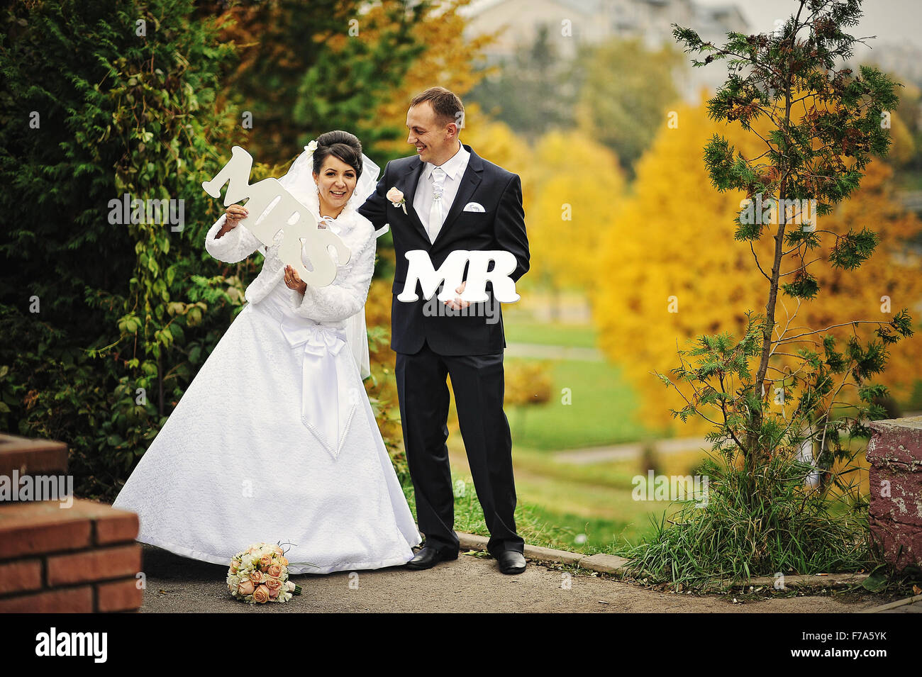 Mrs. Photo Happy wedding couple in autumn day with sign mrs & mr Stock Photo - Alamy