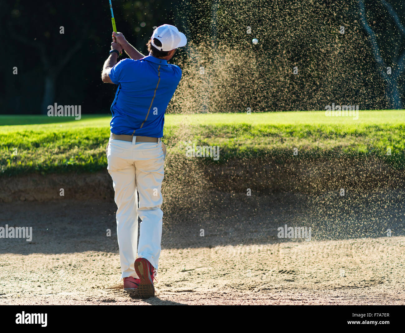 Man playing a shot out of the bunker. Montenmedio golf course. Cadiz, Andalusia, Spain. Stock Photo