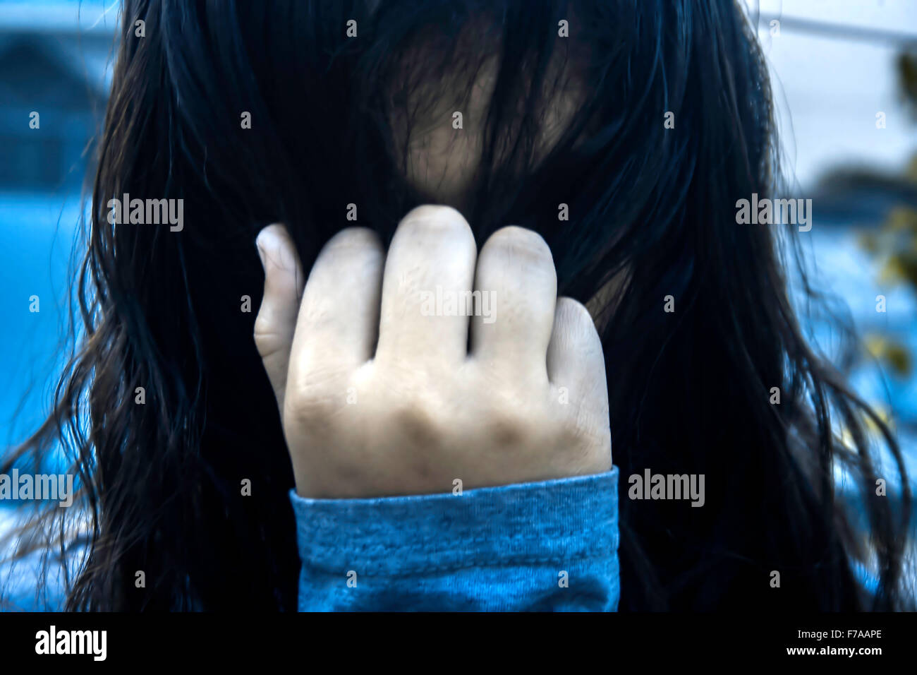 Young girl pulling her hairs to cover face Stock Photo - Alamy