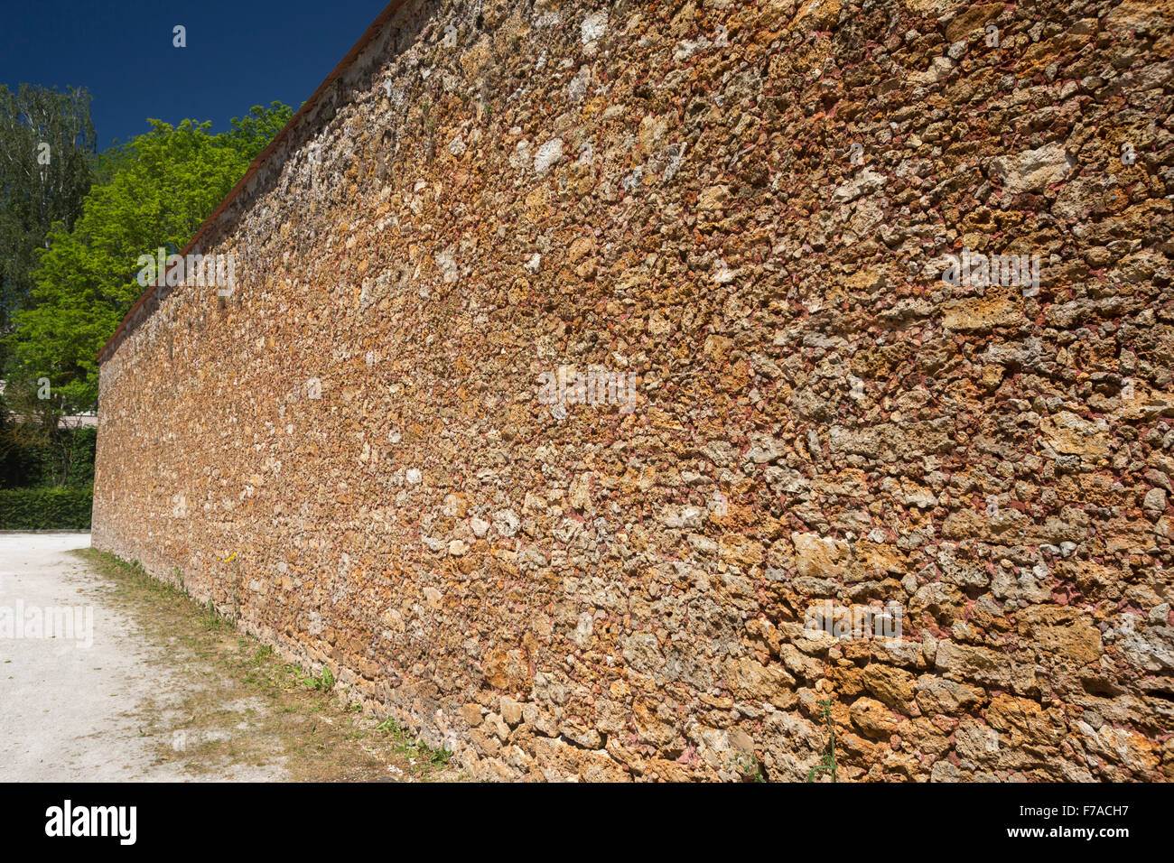 The gritstone outer walls of the old prison of Coulommiers (France). Mur en pierre meulière de l'ancienne prison de Coulommiers. Stock Photo