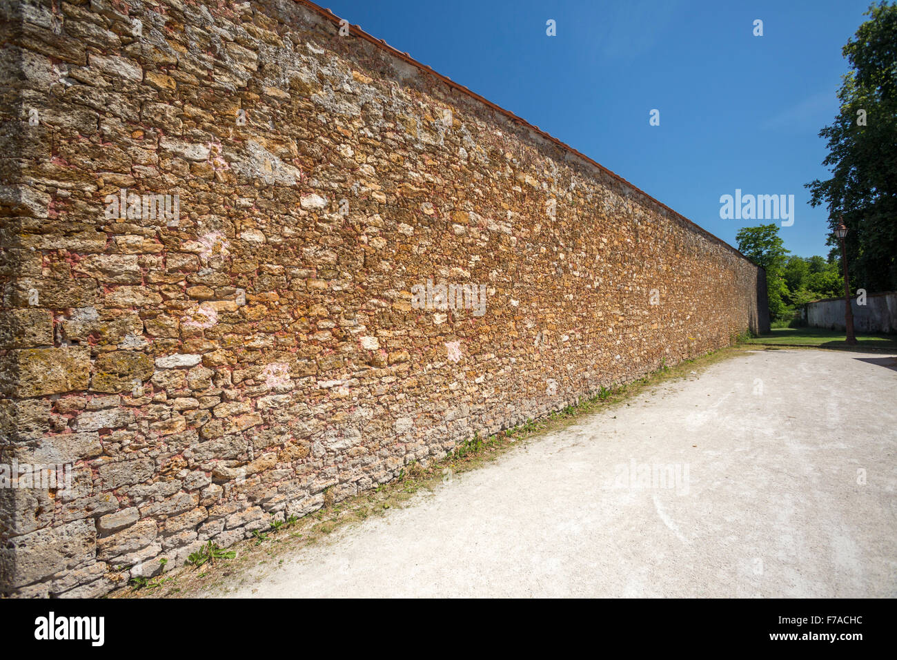 The gritstone outer walls of the old prison of Coulommiers (France). Mur en pierre meulière de l'ancienne prison de Coulommiers. Stock Photo