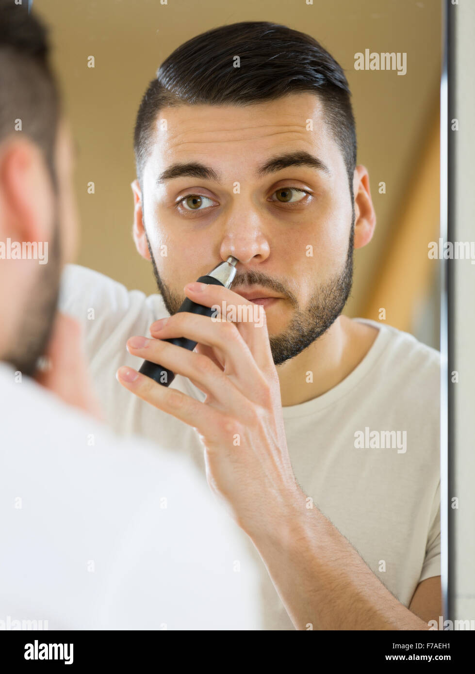 Male Remove Hair From His Nose And Ears With Trimmer Stock Photo