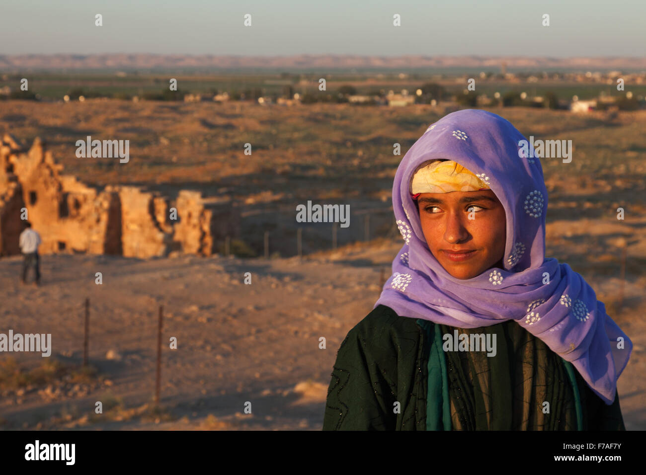 Young Turkish-Arab girl standing in front of the ruins of ancient Harran University and Ulu Mosque with her  traditional scarf Stock Photo