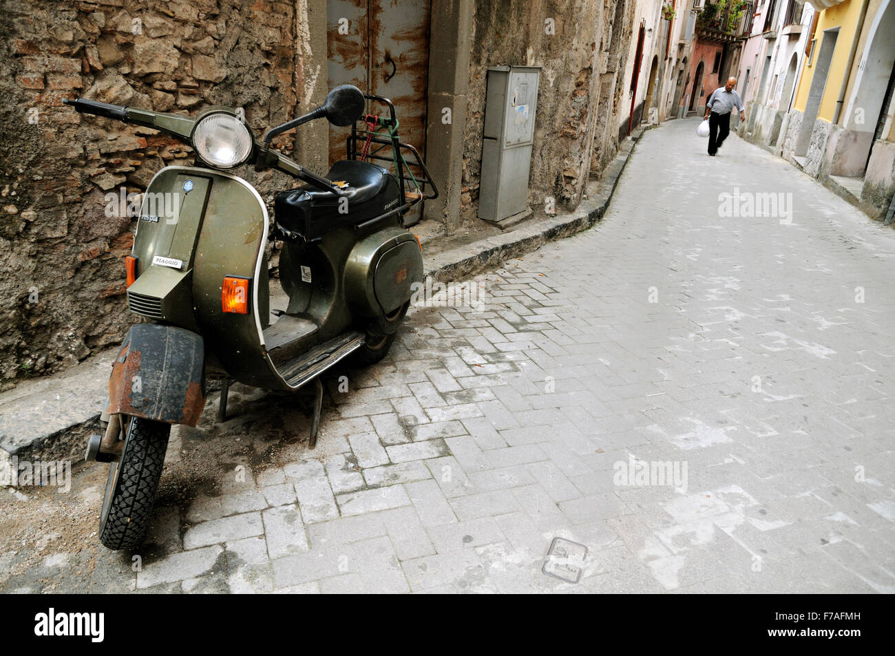 Old green Piaggio scooter parked in a narrow street of Forza d'Agrò, Sicily, Italy Stock Photo