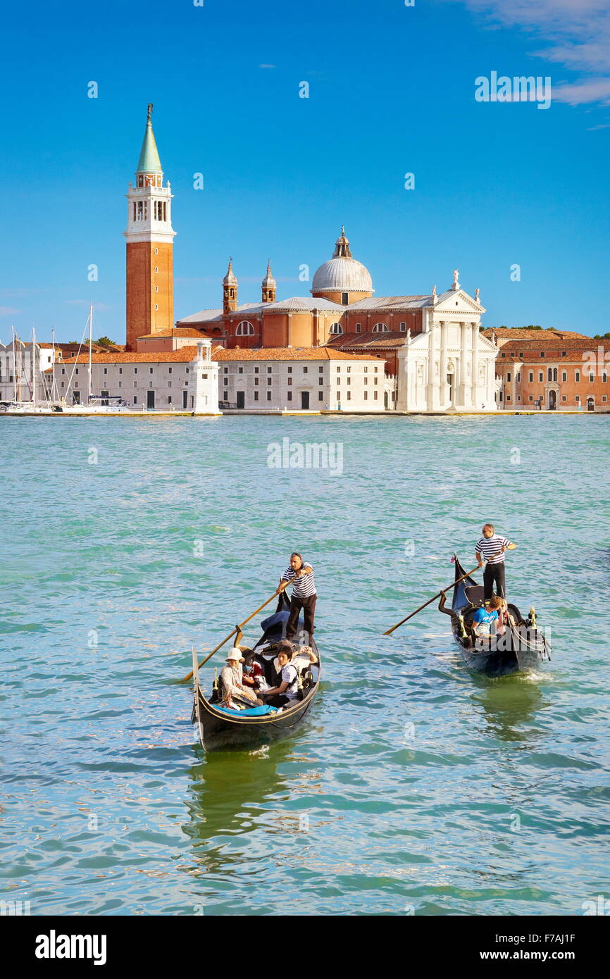 Tourists in venetian gondola on Grand Canal (Canal Grande) and San Giorgio Maggiore church in the background, Venice, Italy Stock Photo