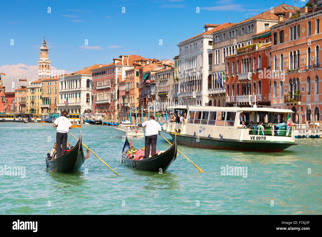 Two venetian gondolas and waterbus on Grand Canal (Canal Grande) - Venice, Italy Stock Photo