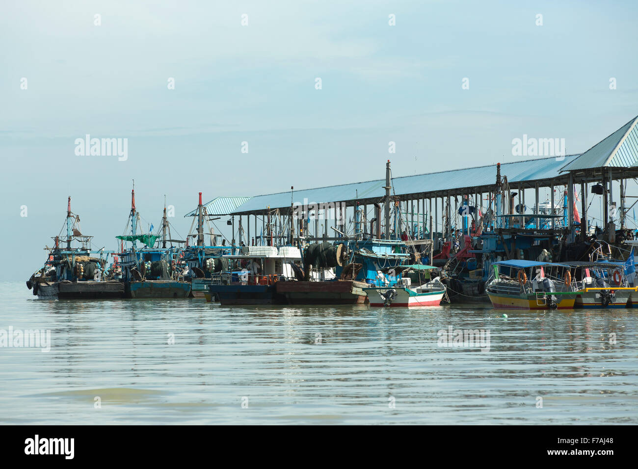 Collection of fishing boats alongside an old jetty at Teluk Bahang in Penang Malaysia. Stock Photo