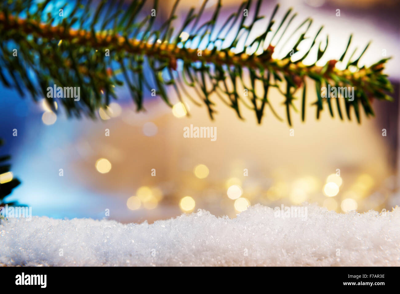 Image of a branch and artificial snow with bokeh lights in background and free space Stock Photo