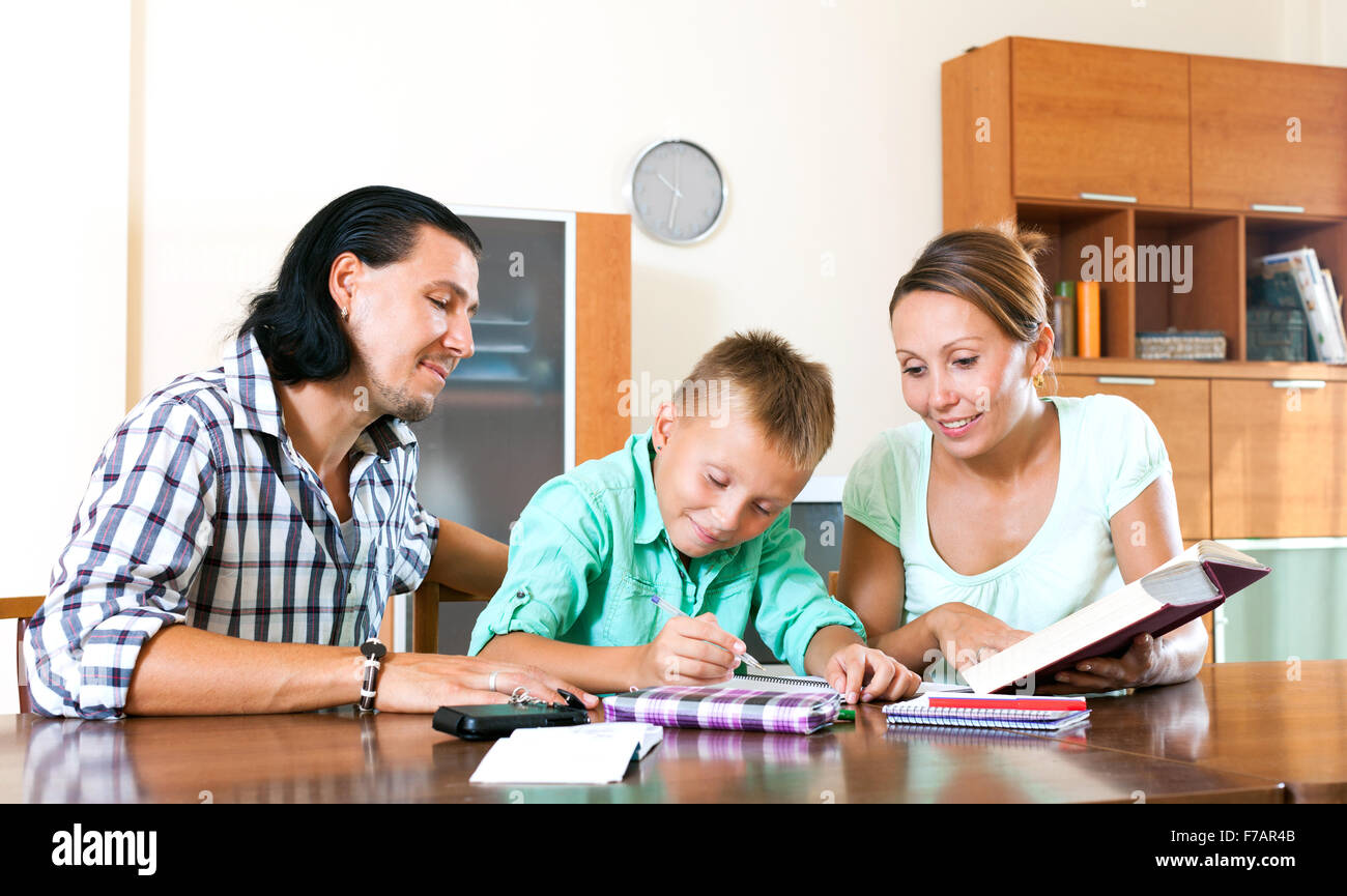 Ordinary family of three doing homework in home interior Stock Photo