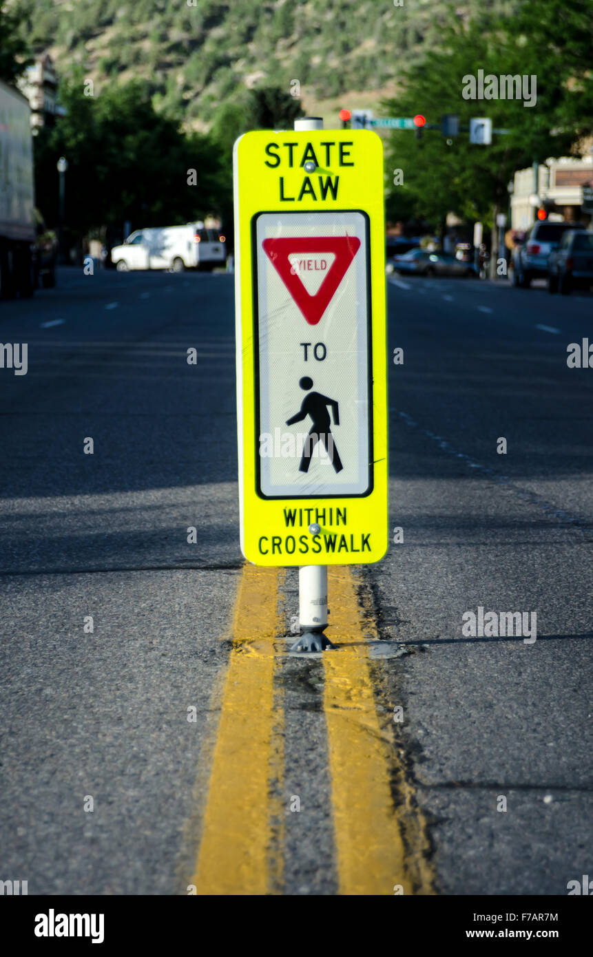 A stop sign reminders drivers in a busy downtown area to yield to pedestrians Stock Photo