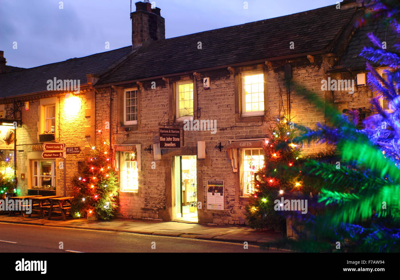 Christmas trees strung with fairy lights line the main street in Castleton, a pretty village in Derbyshire's Peak District,UK Stock Photo