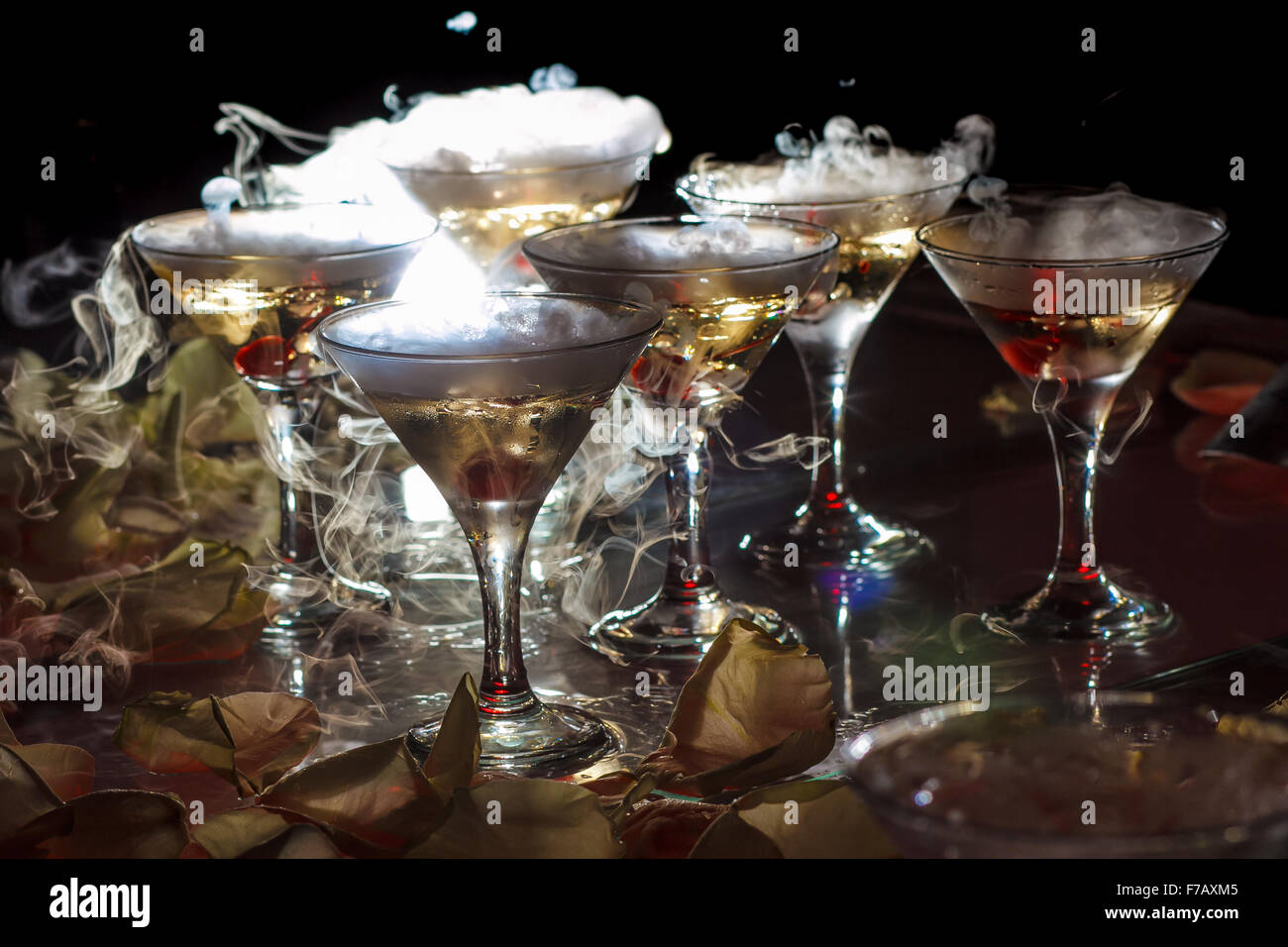 drink in glasses with the effect of dry ice on black background Stock Photo