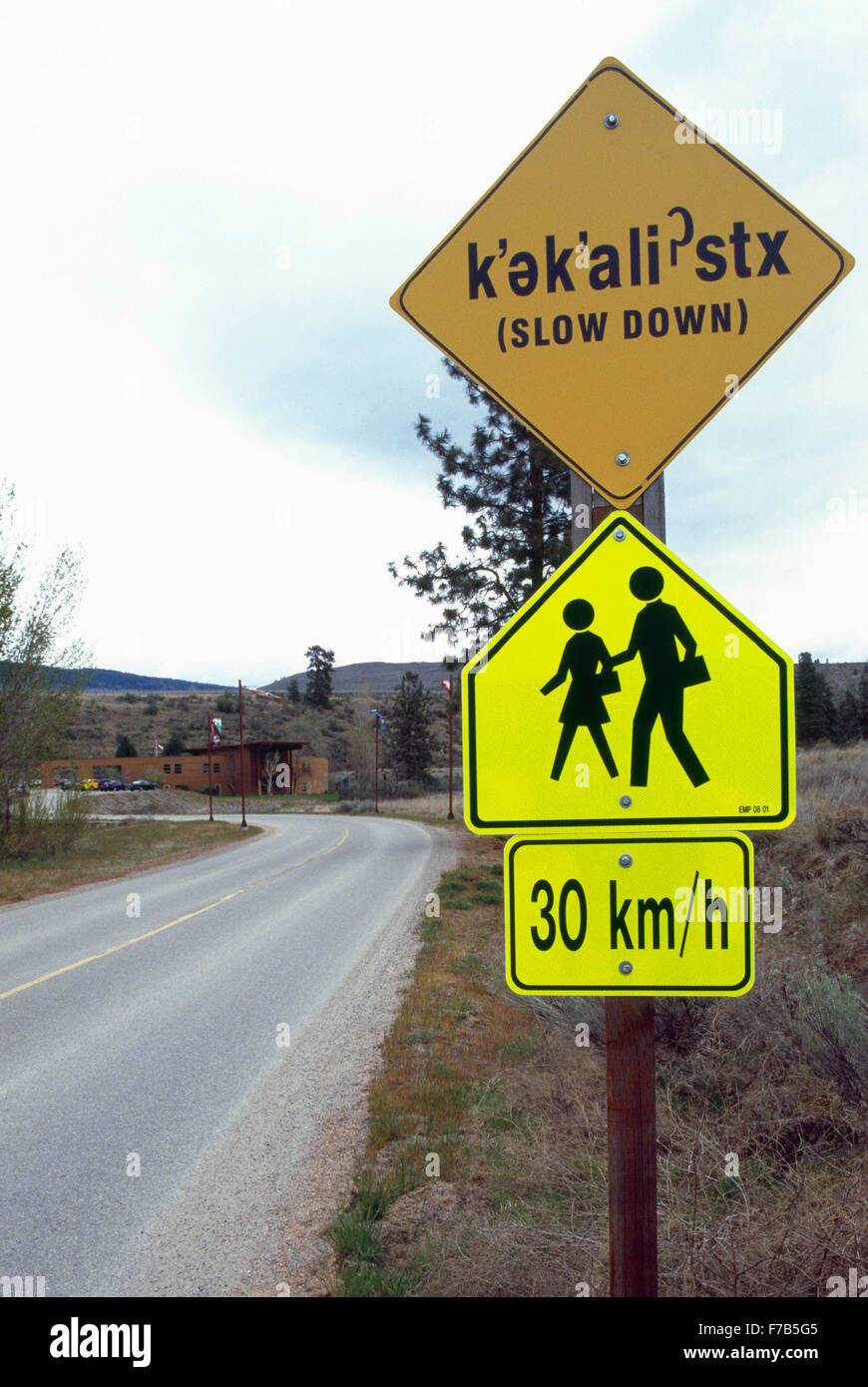 Bilingual Sign in Okanagan Indian and English Languages, Oliver, British Columbia, Canada - Slow Down, People / Children Walking Stock Photo