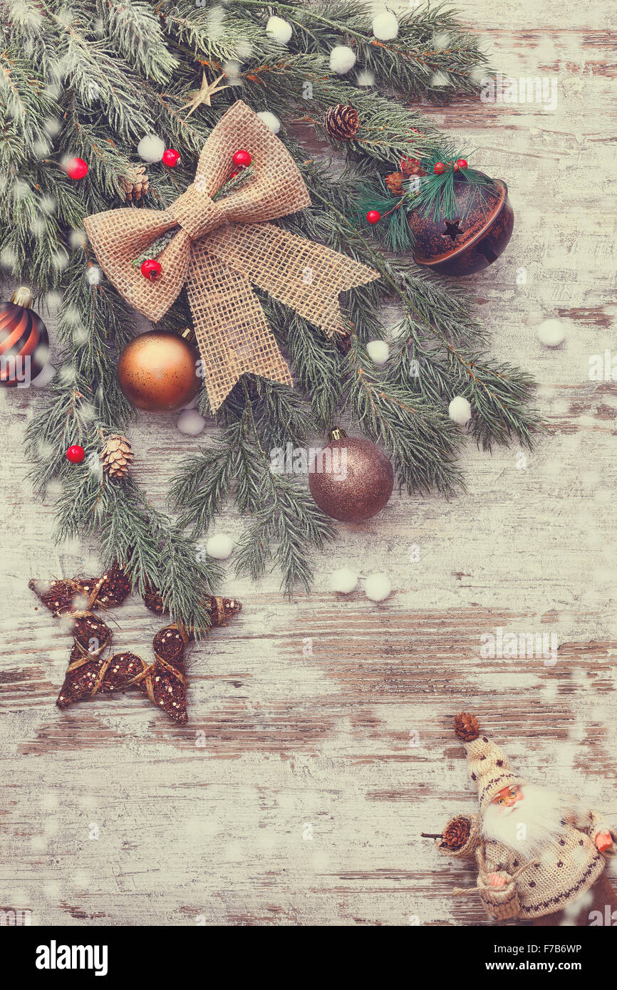 Beautiful Christmas background with snow fir tree. The tip of a tree branch and Christmas decoration on a rustic wood background Stock Photo
