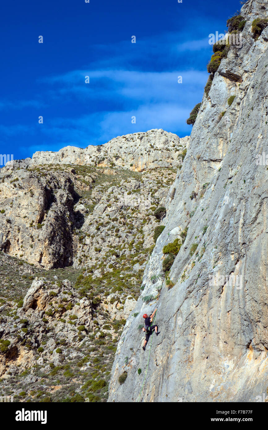 Rock climber on sunny cliff, sport climbing, Greece Stock Photo