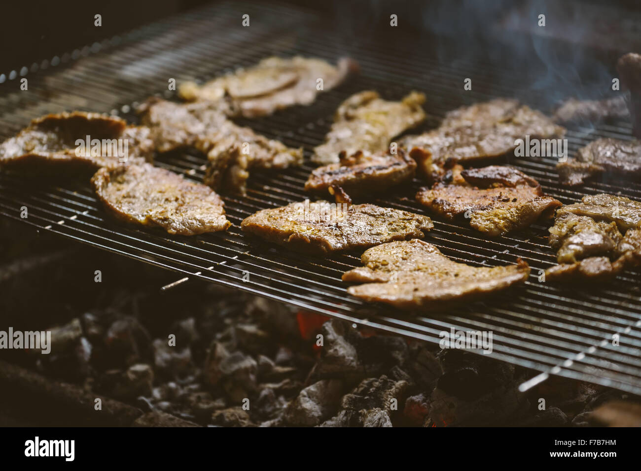 Pork meat chops on barbecue, natural light, retro toned, selective focus with shallow depth of field. Stock Photo