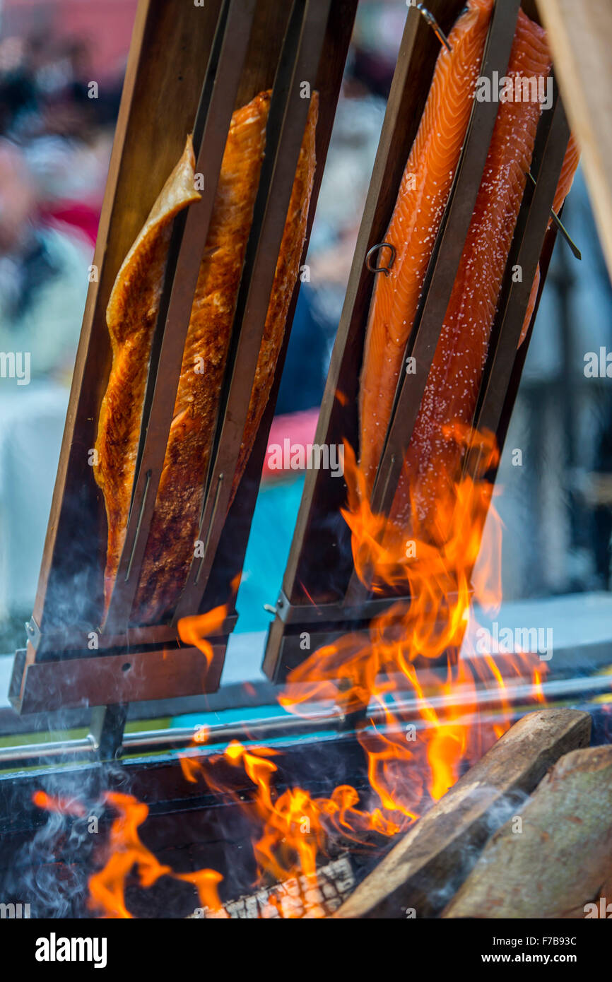 Salmon is smoked and grilled over open fire, specialty on a food market