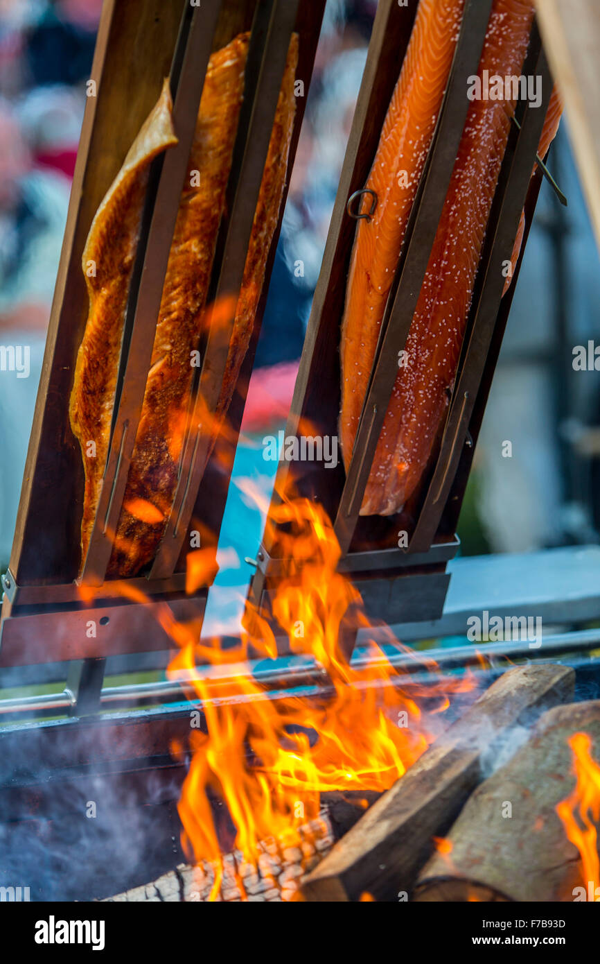 Salmon is smoked and grilled over open fire, specialty on a food market