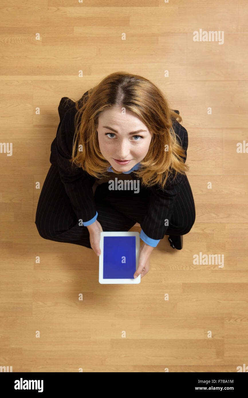 Shot taken from above of a woman sitting cross legged on the floor with