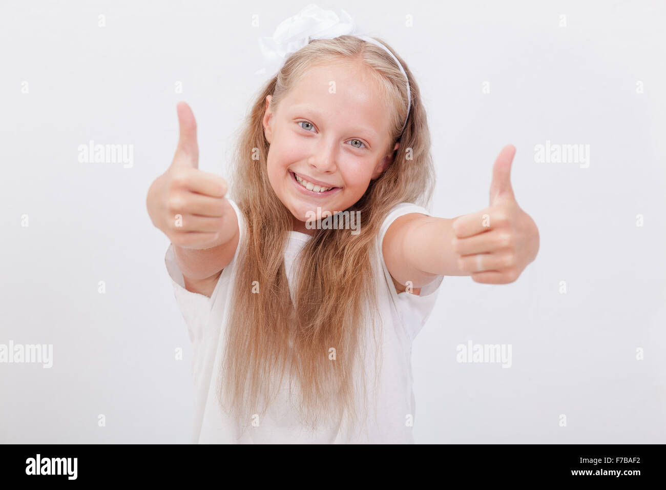 Portrait of a beautiful girl showing thumbs up on white Stock Photo - Alamy
