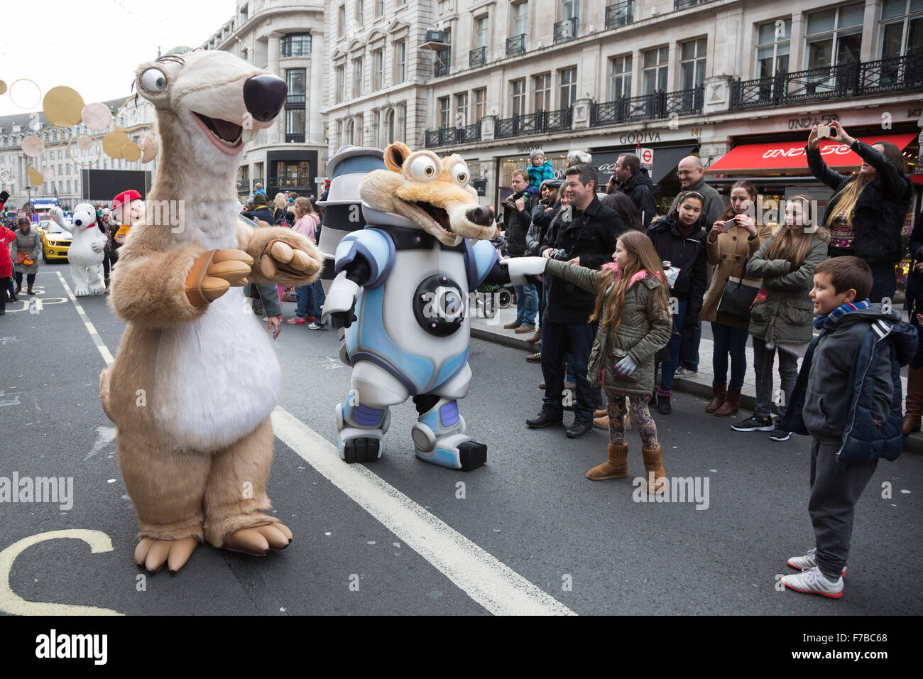 London, UK. 28 November 2015. Sid and Scrat from the Ice Age film interact with young fans. The inaugural Hamleys Christmas Toy Parade takes place along Regent Street, which went traffic-free for the day. The parade organised by the world-famous toy store Hamleys featured over 50 of the nation's favourite children's characters along with 400 entertainers, a marching band and giant balloons. The parade is modelled on Macy's annual Thanksgiving Parade in New York. Credit:  Vibrant Pictures/Alamy Live News Stock Photo