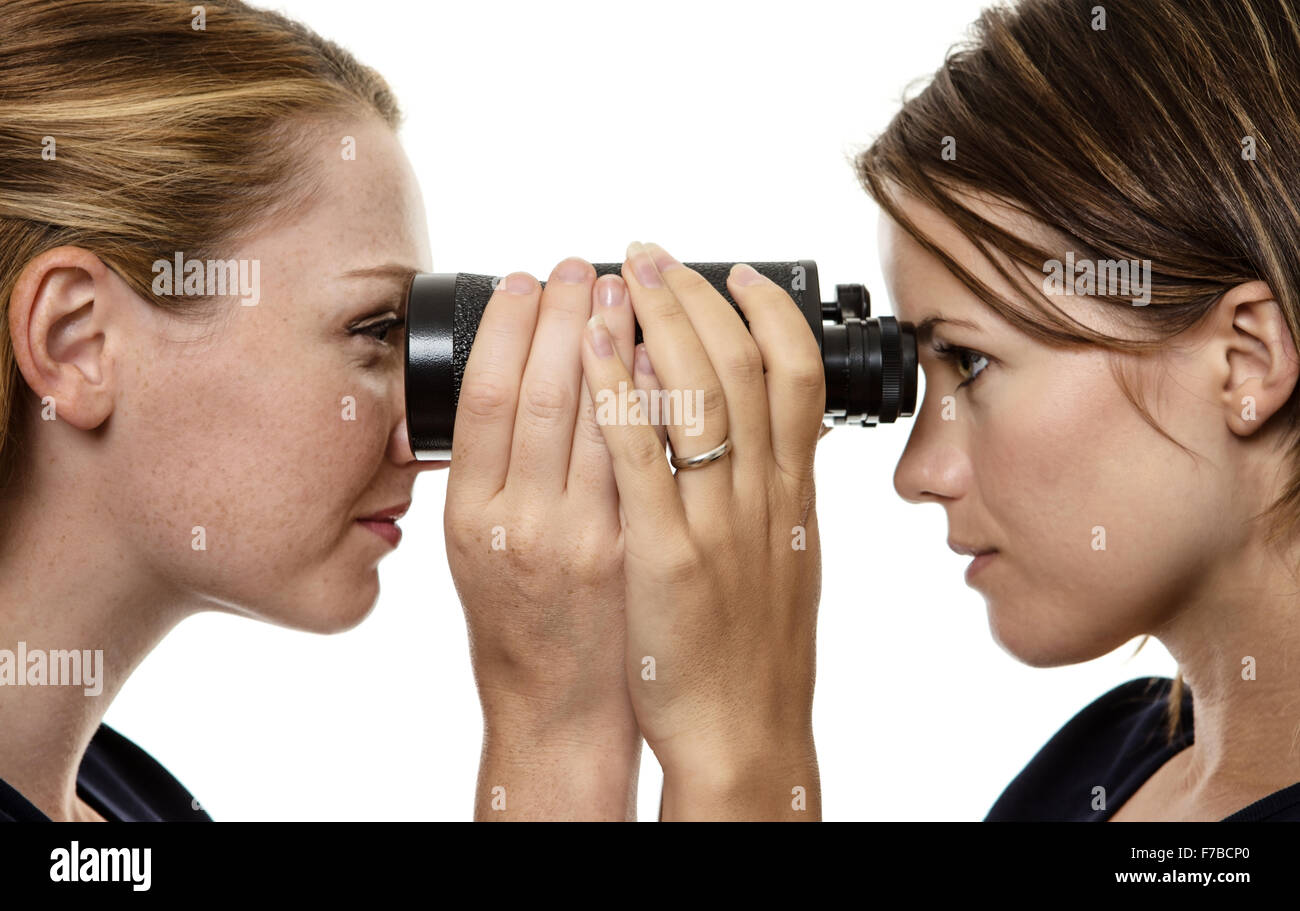 Two business woman looking through the same pair of binoculars Stock Photo