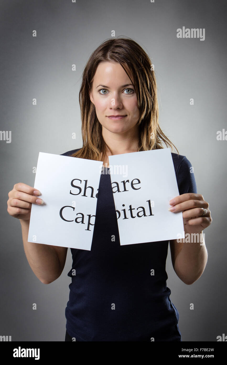stand woman cutting paper in half with the word share capital written