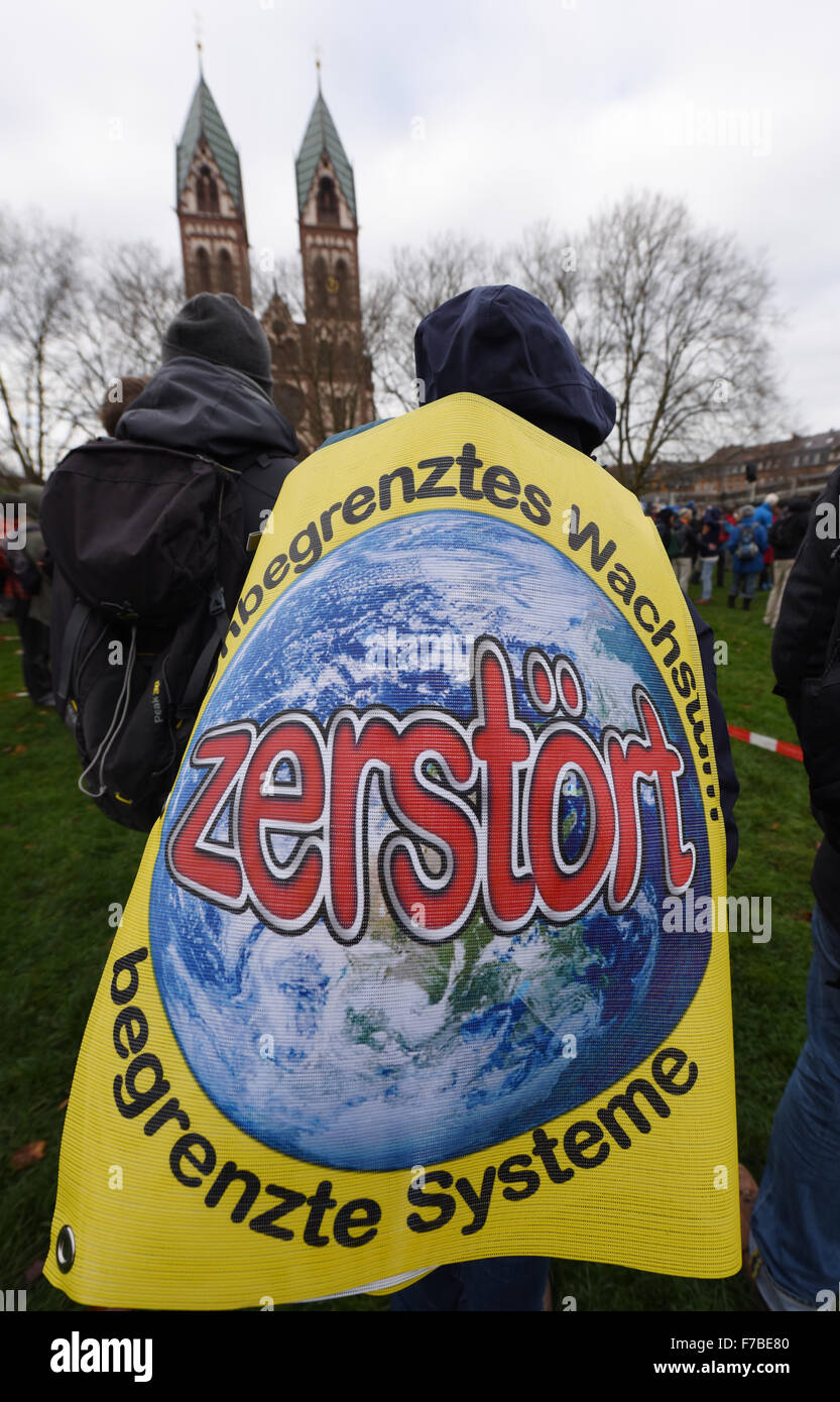 Freiburg, Germany. 28th Nov, 2015. An environmental protestor wears a banner that reads 'Unbegrenztes Wachstum zerstoert begrenzte Systeme' (lit. unlimited growth destroys limited systems) in Freiburg, Germany, 28 November 2015. In the run up to the Climate Summit in Paris on 30 November, demnostrations took place in the south-west of Germany. Police in Freiburg counted around 1200 demonstrators. PHOTO: PATRICK SEEGER/DPA/Alamy Live News Stock Photo