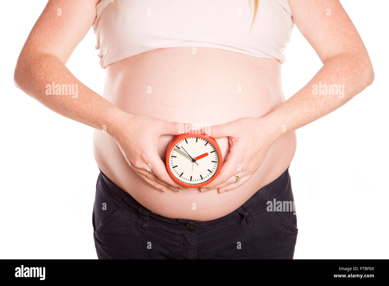 Pregnant women holding a clock on white background Stock Photo