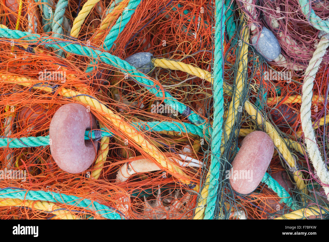 Beautiful bright coloured fishing netting and floats stored on the harbour at Astrakeri, Corfu Stock Photo