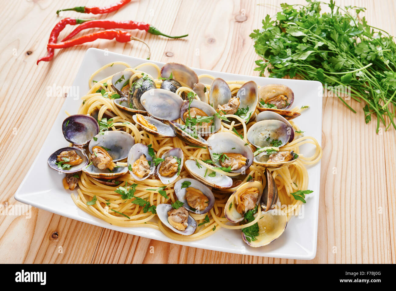 Pasta with steamed clams on white square plate Stock Photo Alamy