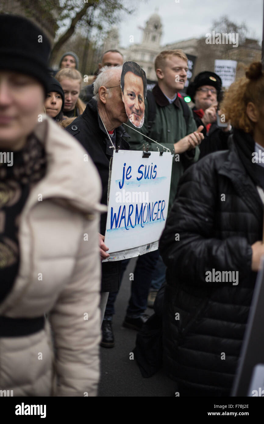 10 Downing Street, London, UK 28th November 2015. Man wears Cameron mask with sign reading 'Je Suis Warmonger'. LOUISA BREMNER/Alamy Live news Stock Photo