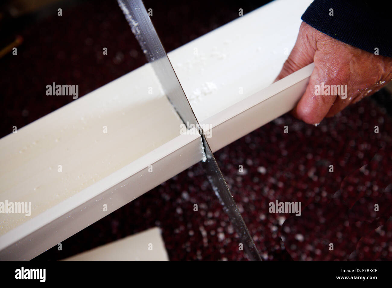 Handsaw sawing through board Stock Photo