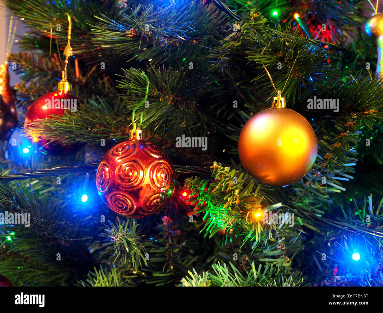 Colourful colorful display of festive lights and decorations on an artificial Christmas tree Stock Photo