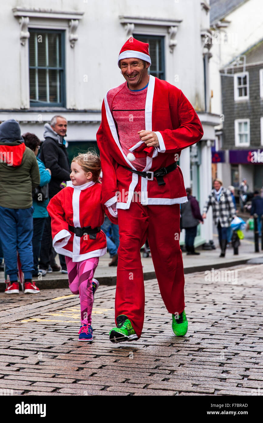 Bodmin Santa Fun Run. Bodmin, Cornwall, England. 28th November 2015. Bodmin Santa Fun Run organised by the Charity, Cornwall Hospice Care. The Santa’s, Runners, Finishing the Run. Credit:  Barry Bateman / Alamy Live News Stock Photo