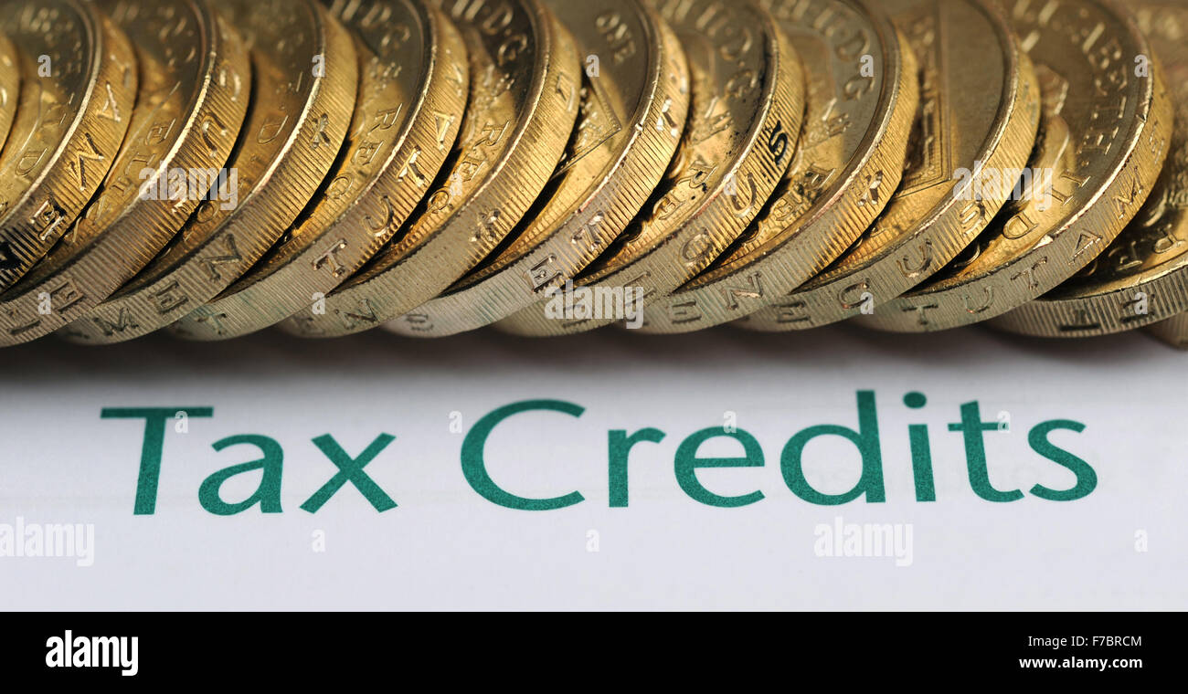 TAX CREDITS FORM WITH ONE POUND COINS RE WORKING TAX CREDIT  WELFARE BENEFITS  REVENUE LOW INCOME FAMILY LIVING MINIMUM WAGE UK Stock Photo