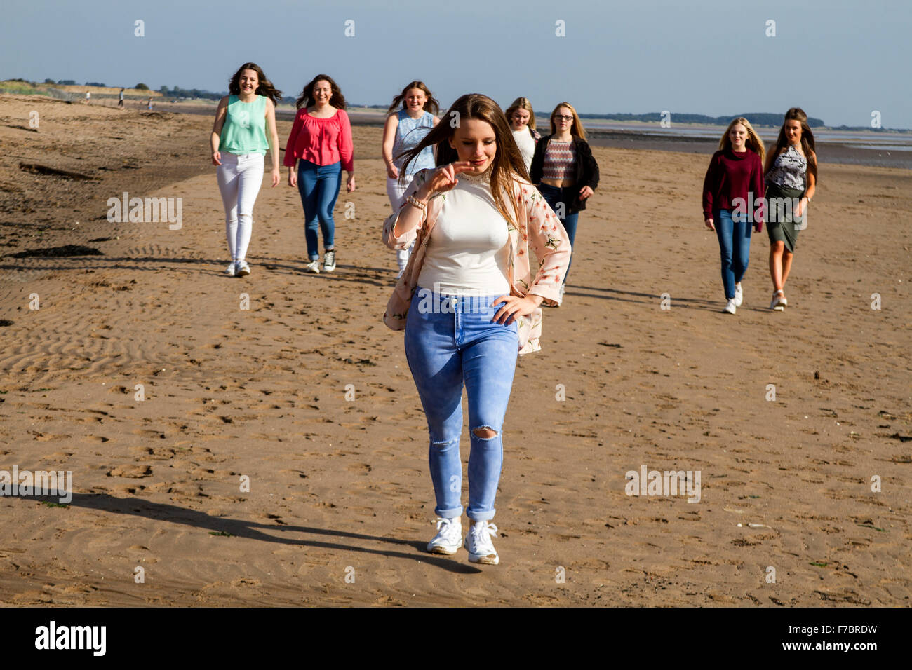 A group of teenage girls enjoying a fun day out walking along the sandy beach at Broughty Ferry