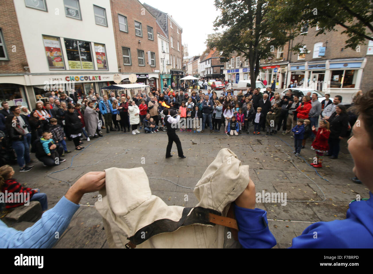 Street performer breathing fire with assistants holding a straight jacket, in York 2015 Stock Photo