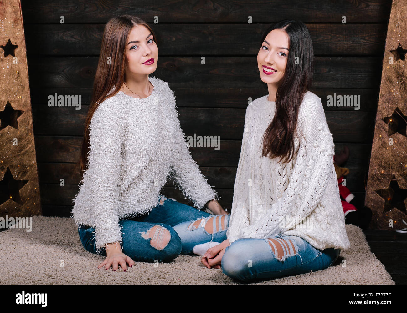Two beautiful girls sitting on the floor Stock Photo - Alamy
